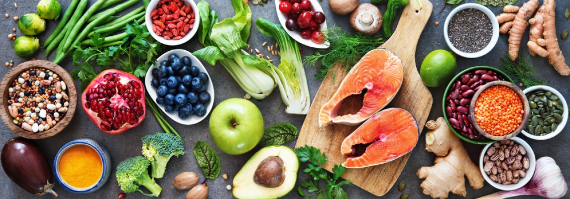 Healthy food selection: food sources of omega 3 and unsaturated fats, fruits, vegetables, seeds, superfoods with high vitamin e and dietary fiber, cereals on gray background